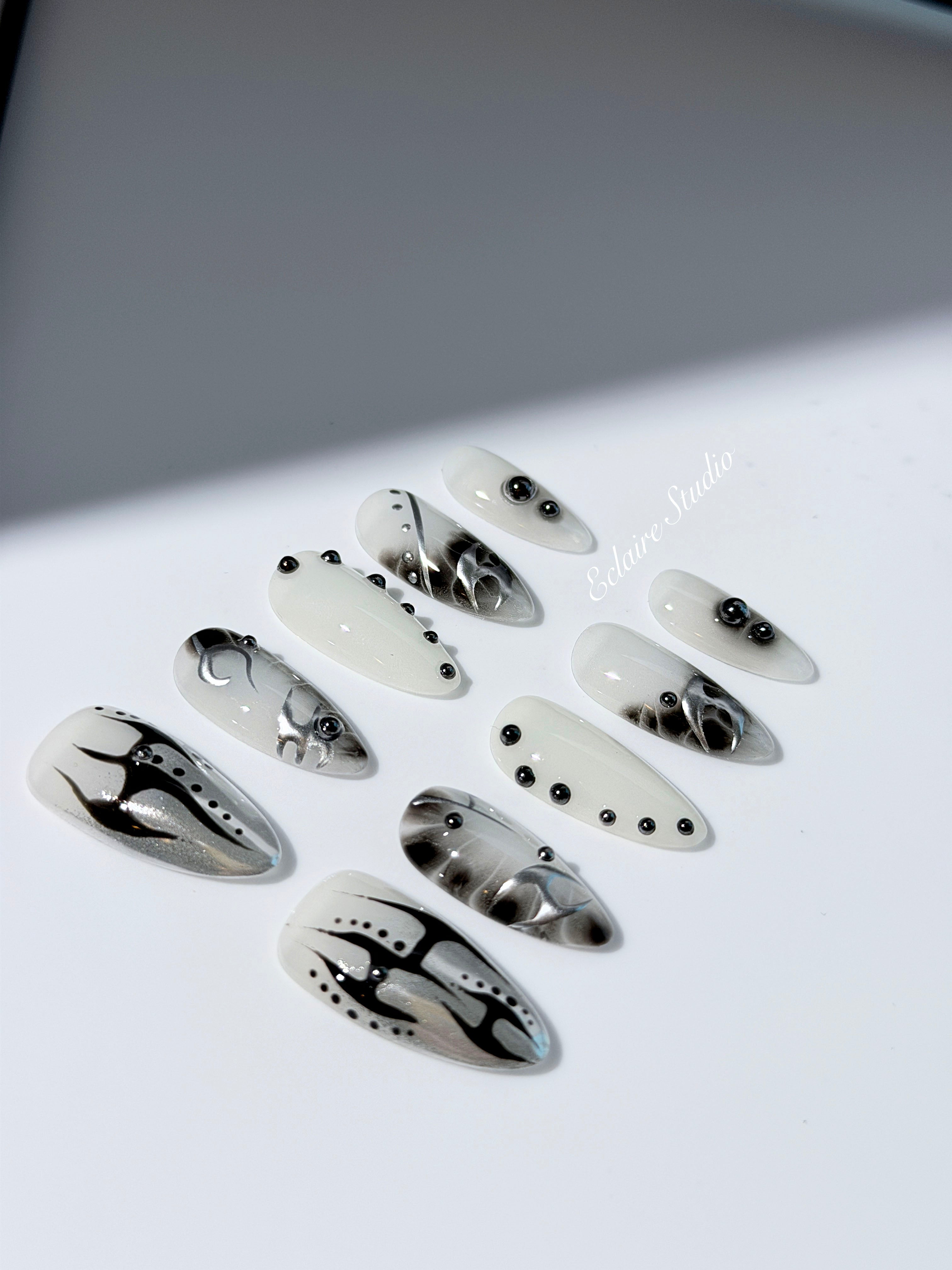 oid Signal press-on nails — a black and grey smoky marble nail design with cyber-inspired line art and glossy onyx studs. Handmade high-fashion nails by Éclaire Nail Studio.”