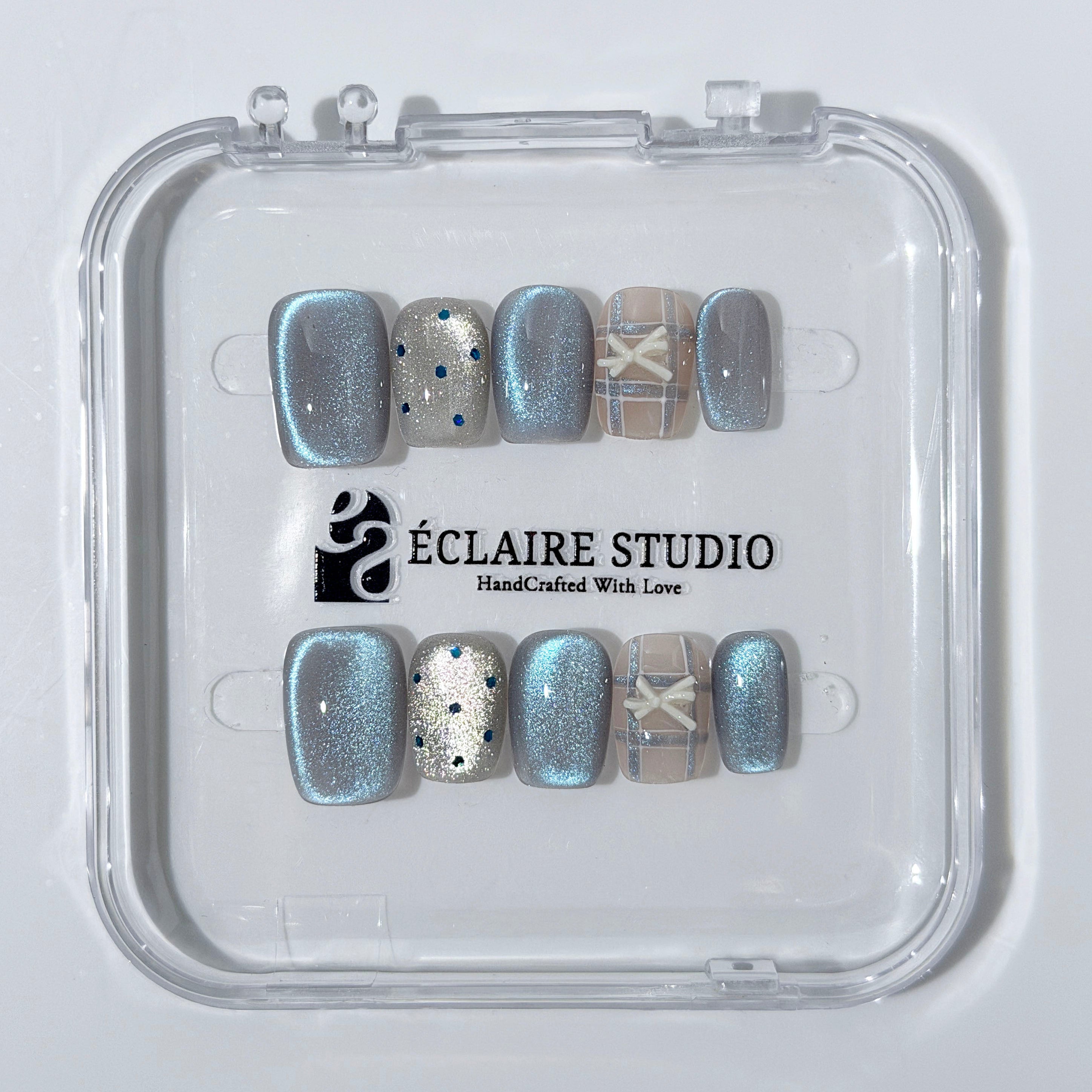 Pastel blue cat-eye press-on nails with glitter accents and 3D clear star details in a soft winter sorbet aesthetic.