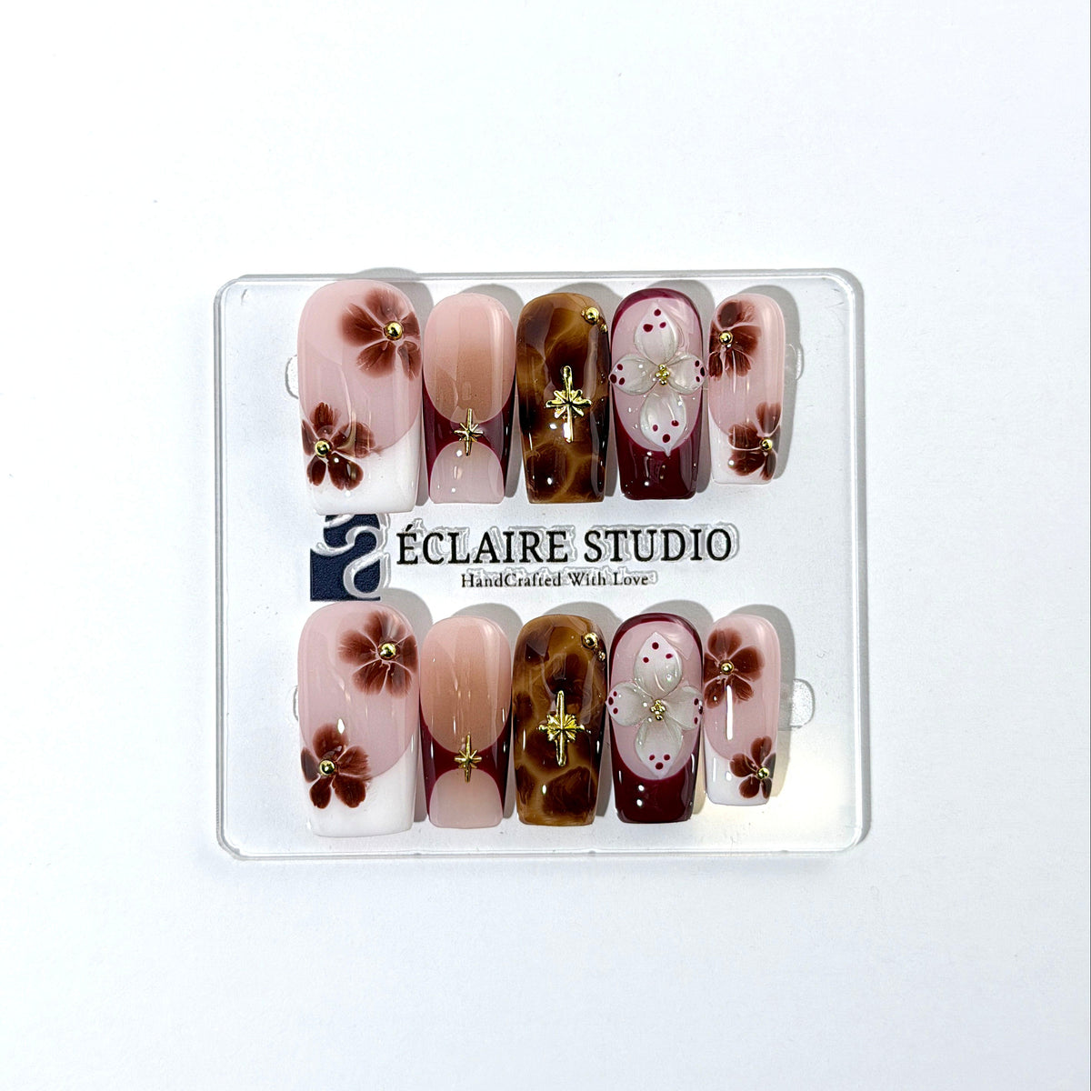 Amber Bloom square press-on nails with blush pink bases, French tips, brown hand-painted flowers, tortoiseshell accents, ivory 3D flowers, and gold details.