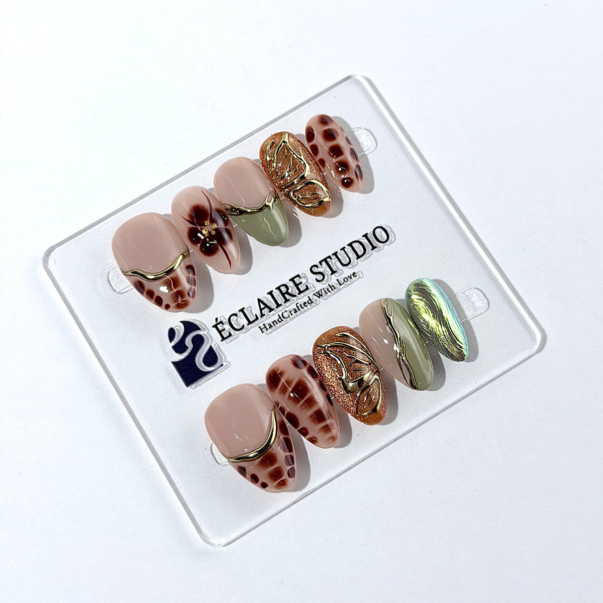 Olive Reverie short almond press-on nails with brown and green cat-eye shimmer, olive French tips, animal prints, floral art, and raised gold details.