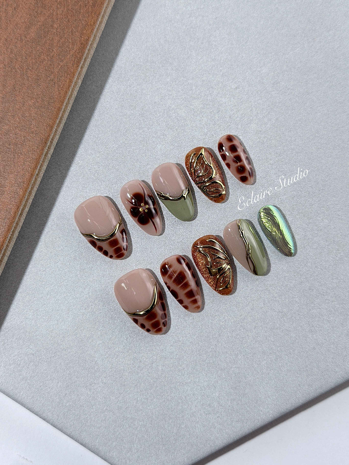 Olive Reverie short almond press-on nails with brown and green cat-eye shimmer, olive French tips and animal print – Éclaire Studio