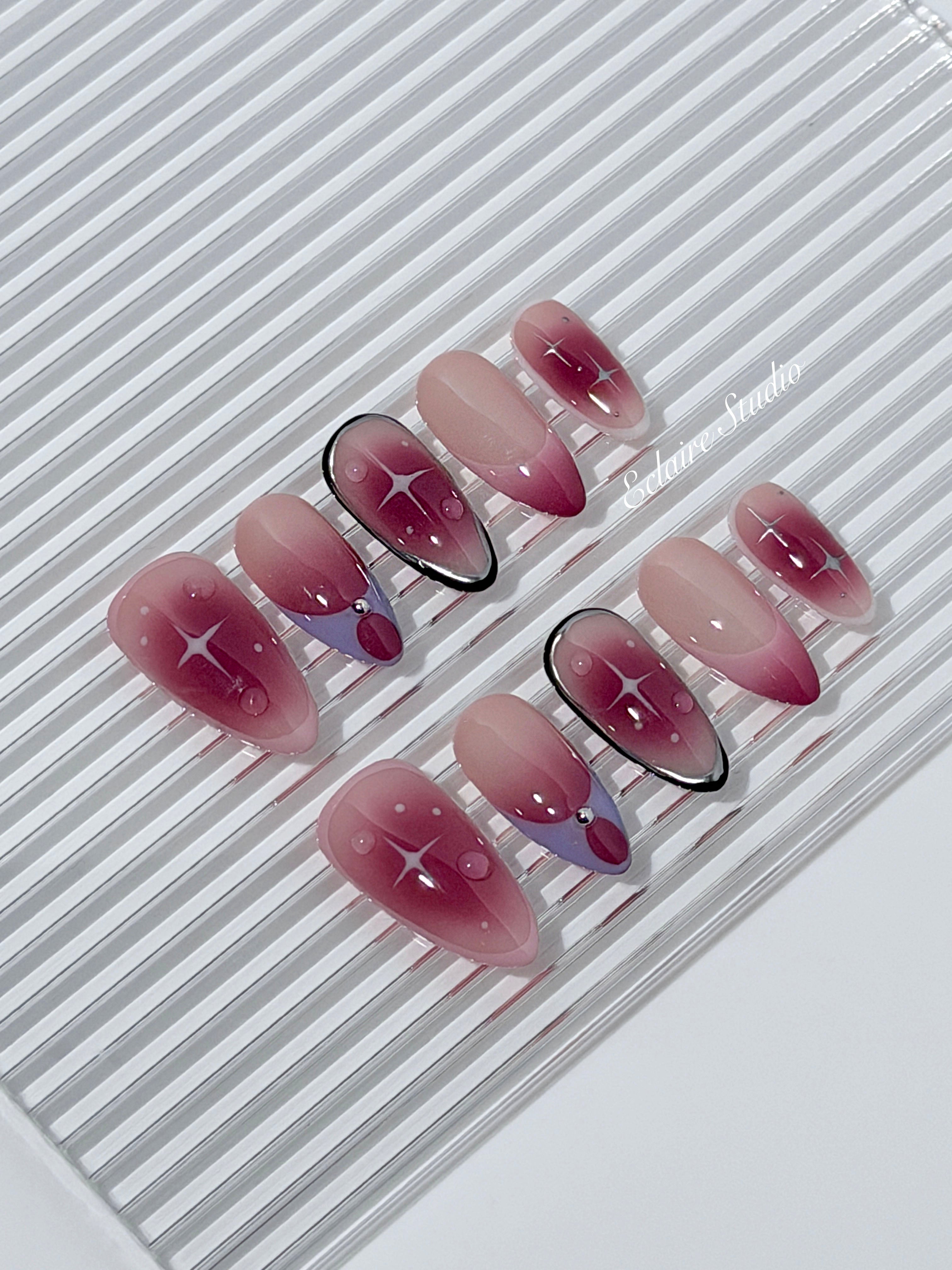 Plum and blush ombré nails with star accents and abstract black outlines — Sugar Plum Fairy–inspired.
