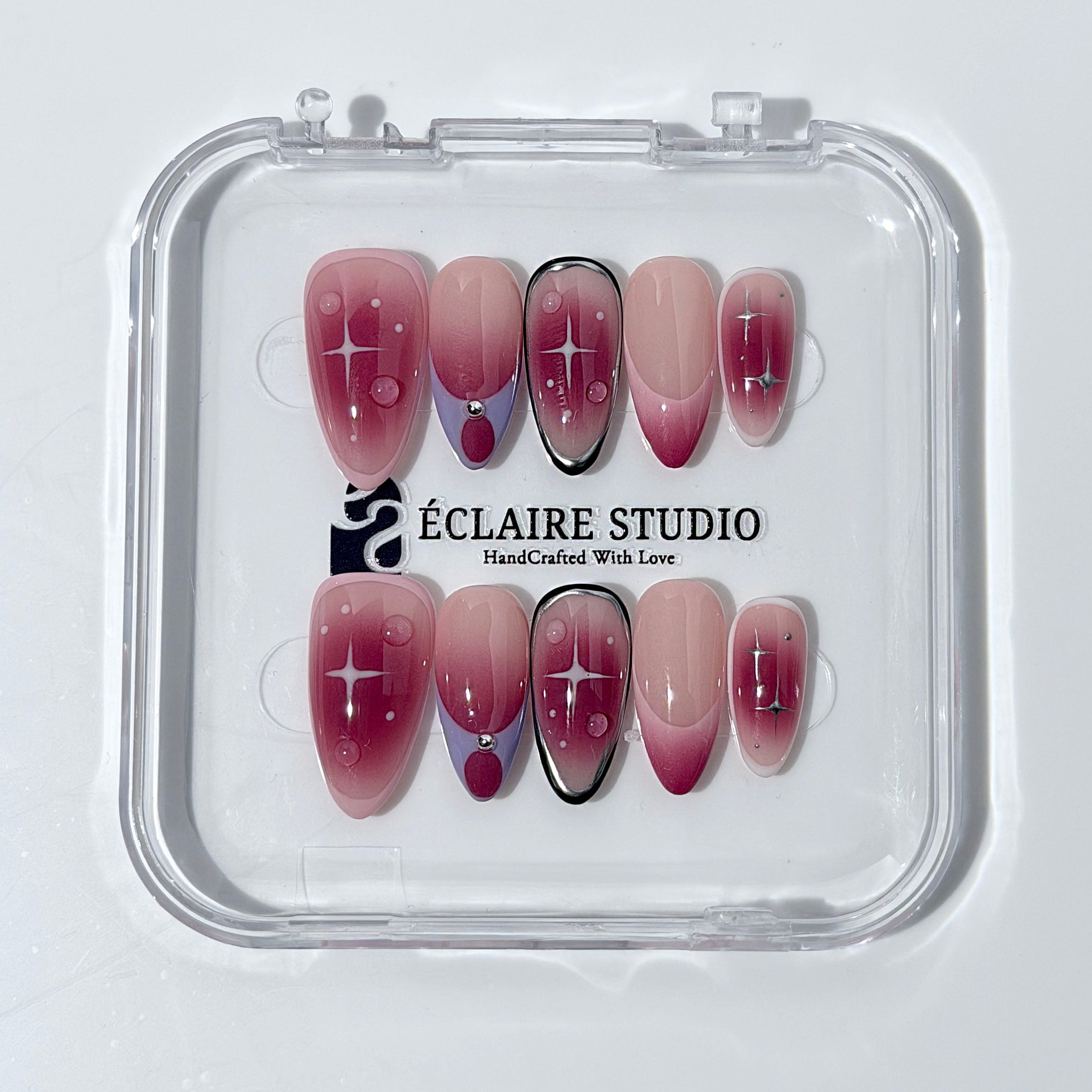 Plum and blush ombré nails with star accents and abstract black outlines — Sugar Plum Fairy–inspired.