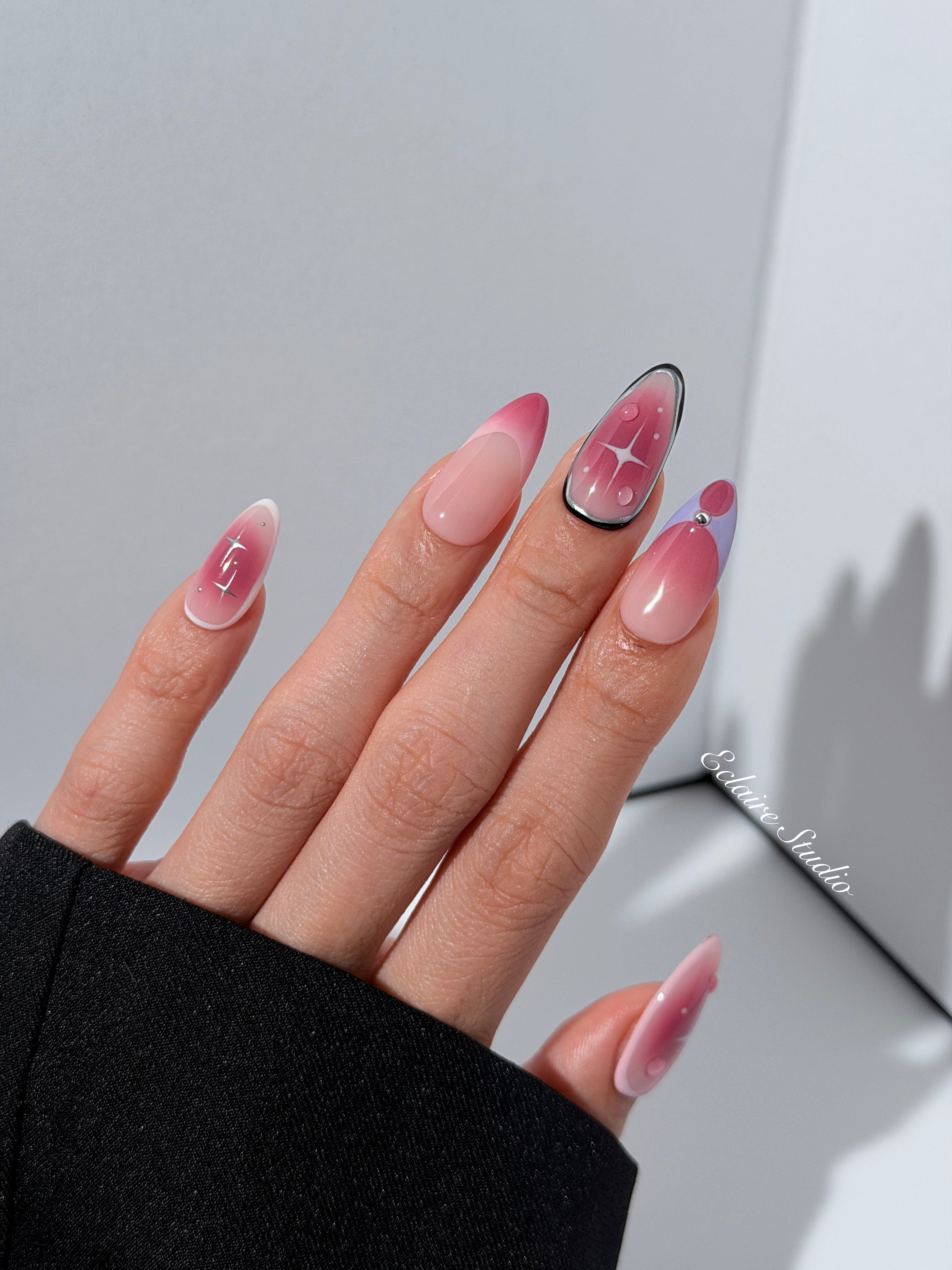 Plum and blush ombré nails with star accents and abstract black outlines — Sugar Plum Fairy–inspired.