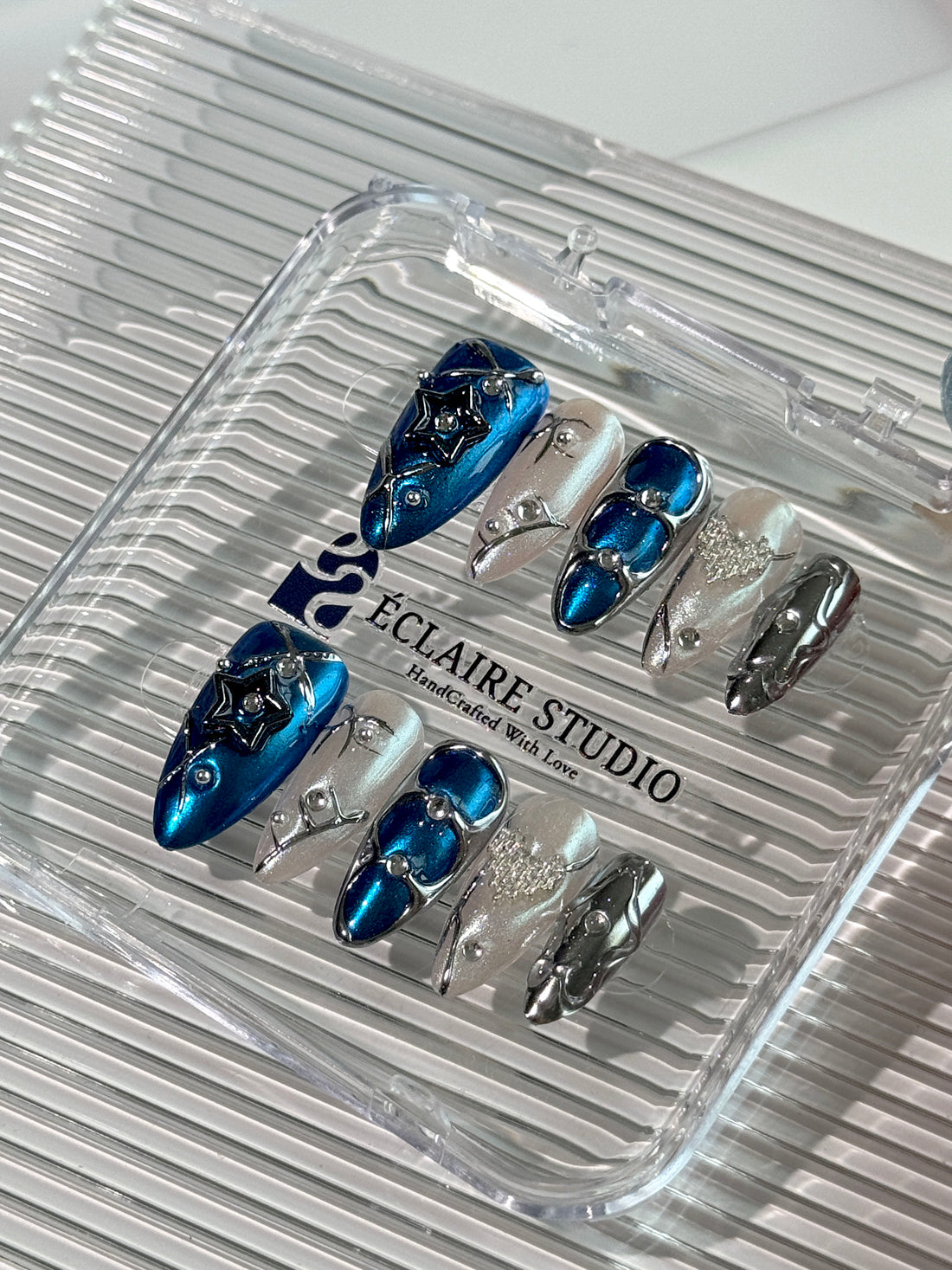 Set of blue and silver nail art designs in a clear case