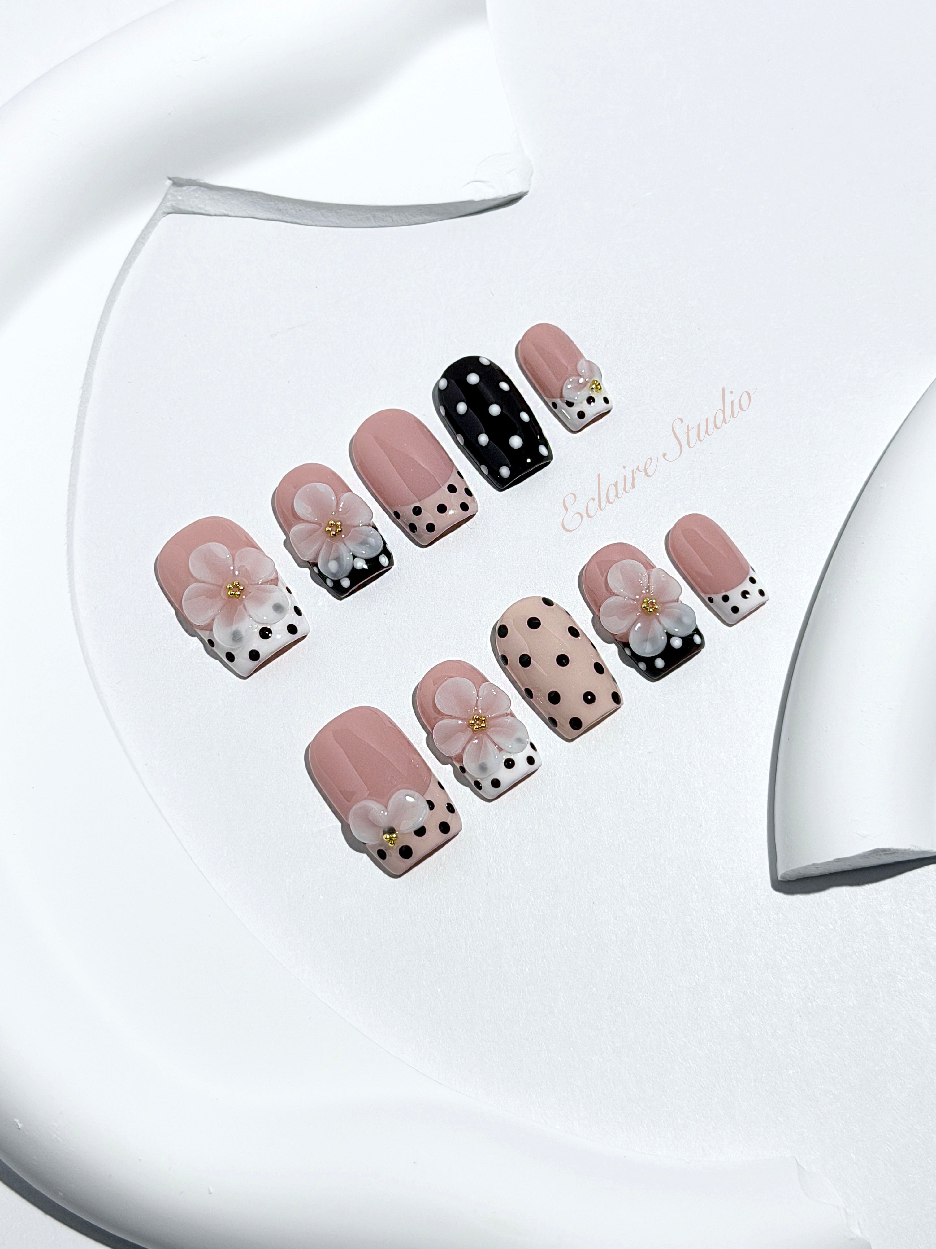 Eclaire Nail Studio 3D Floral Polka dot pink base with alternating black and white polka dot French tips, and hand-sculpted 3D frosted white flowers with gold bead centers, Medium Square