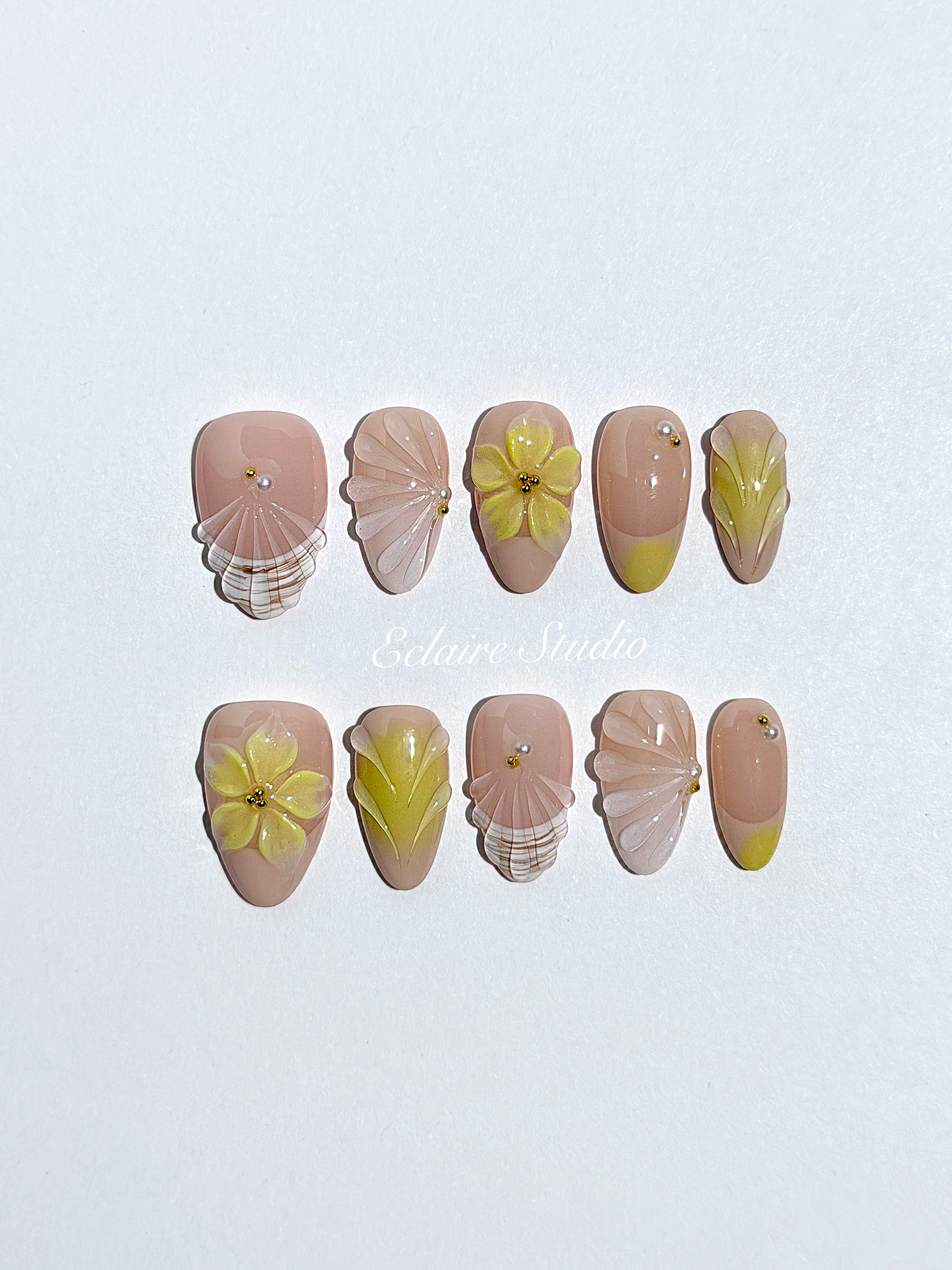 Eclaire Studio Yellow Summer short almond press-on nails featuring a sheer nude base with yellow French tips, hand-sculpted 3D flowers, frosted 3D seashells