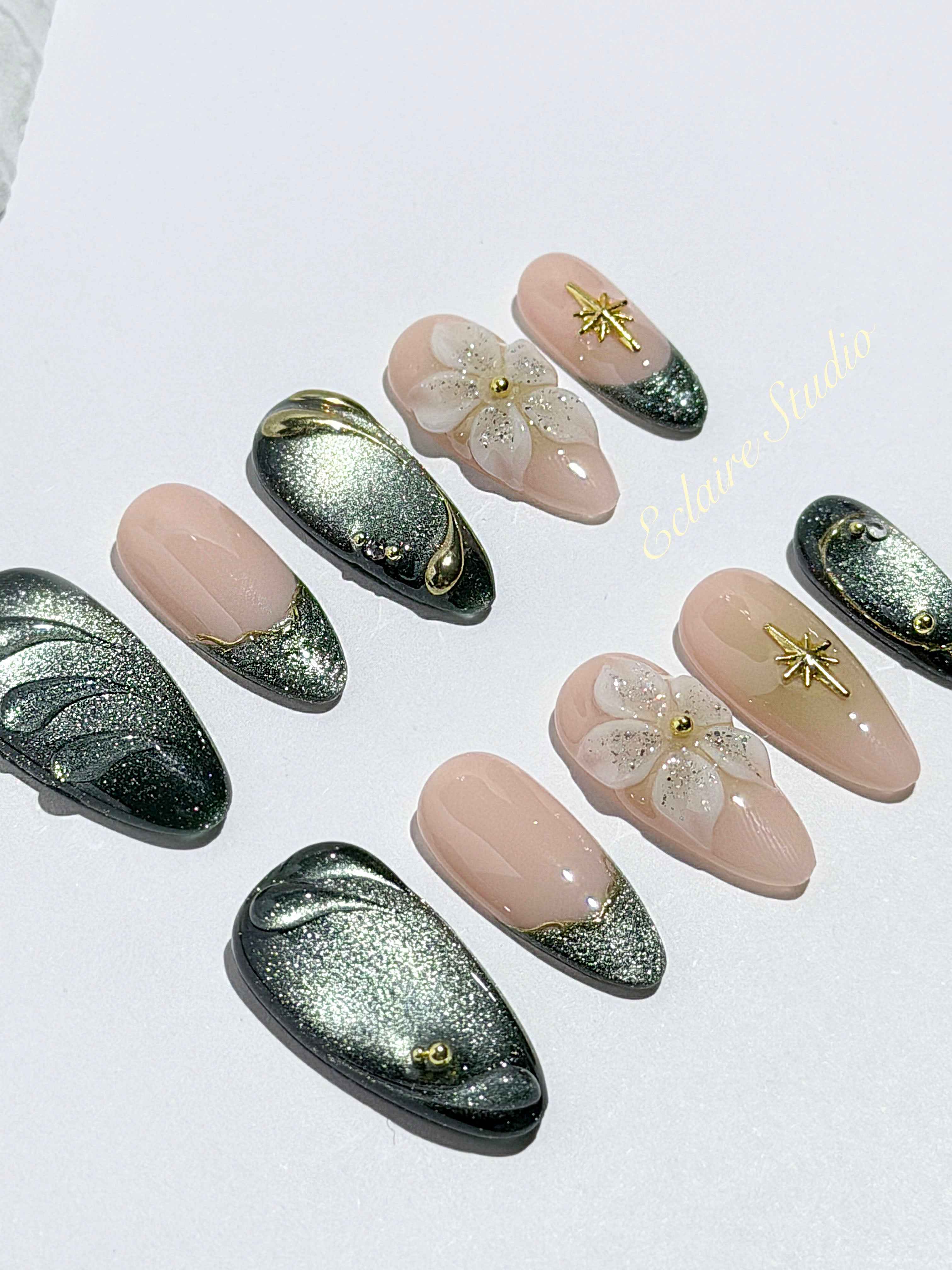 Bali Escape almond press-on nails with emerald cat-eye shimmer, 3D frosted flowers and gold accents – Éclaire Studio