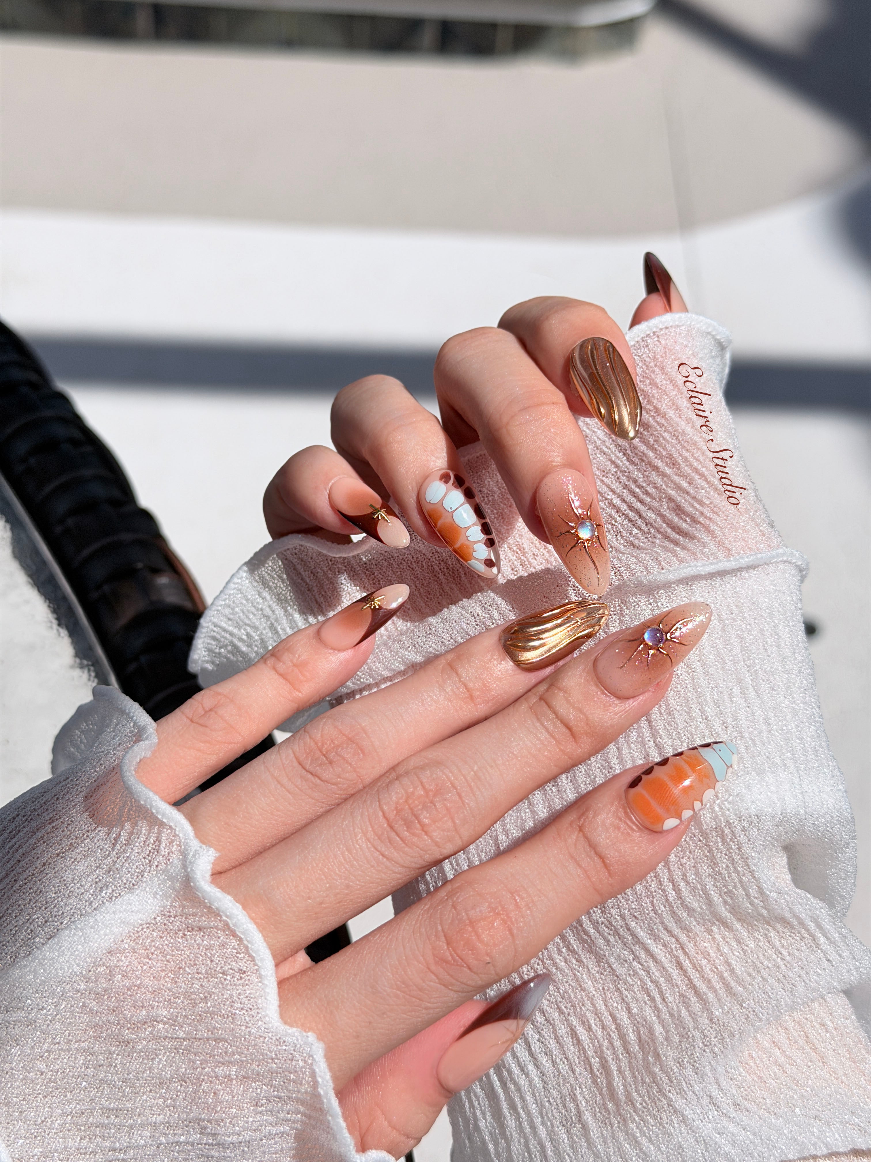 Dune caramel and espresso press-on nails with gold chrome wave, starbursts and opal gem – Éclaire Studio