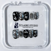 Black and silver press-on nails with 3D chrome swirl accents, star details, and shimmer gradient in a bold winter aesthetic.
Y2K nails