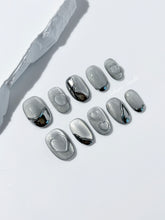 Extra short silver cat-eye press-on nails with chrome ripple accents and 3D heart details, minimalist winter aesthetic.
