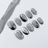 Extra short silver cat-eye press-on nails with chrome ripple accents and 3D heart details, minimalist winter aesthetic.
