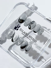 Extra short silver cat-eye press-on nails with chrome ripple accents and 3D heart details, minimalist winter aesthetic.
