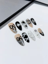 Handmade black, white, and nude press-on nails featuring bows, star charms, and pearl embellishments.