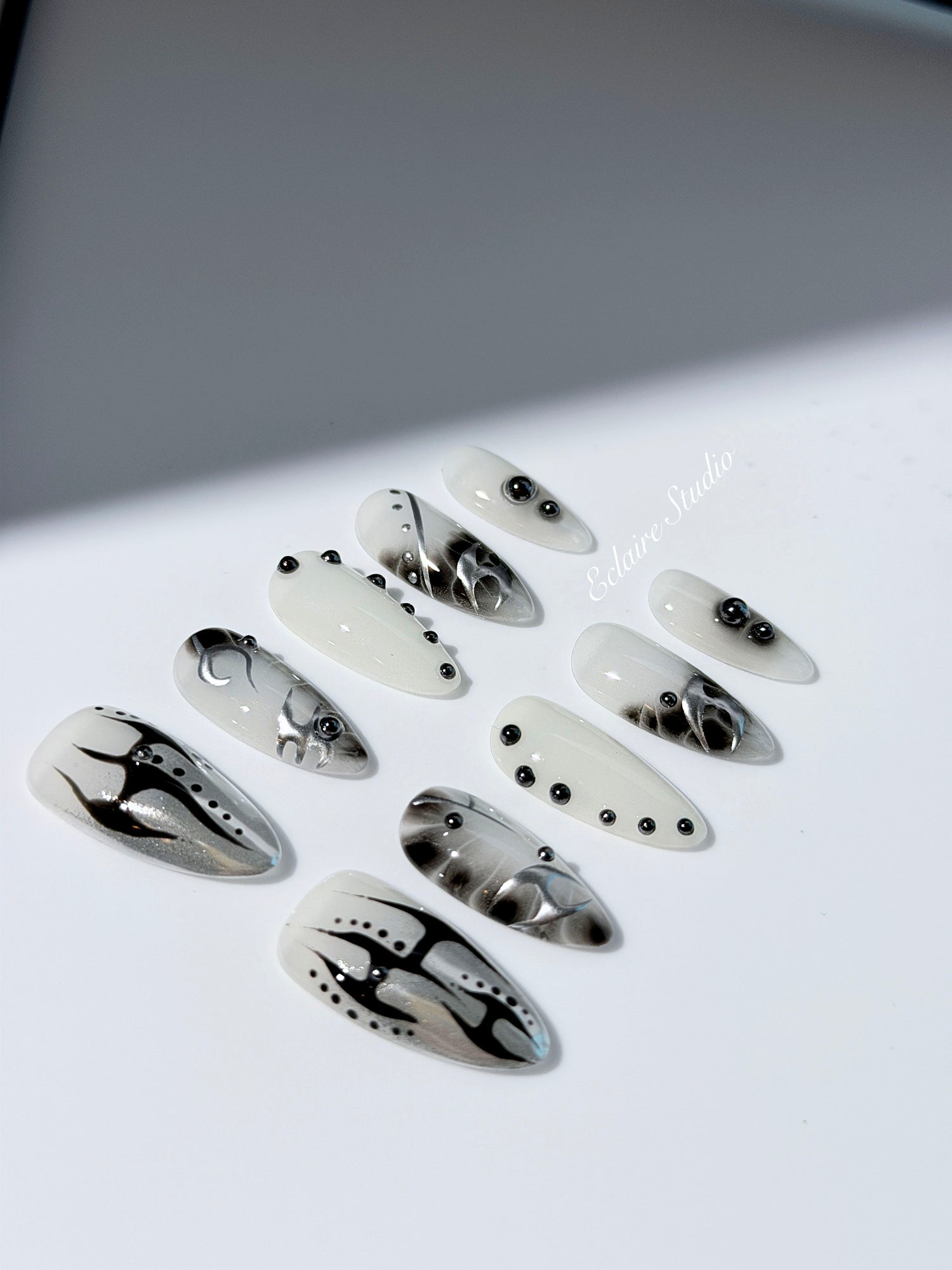 oid Signal press-on nails — a black and grey smoky marble nail design with cyber-inspired line art and glossy onyx studs. Handmade high-fashion nails by Éclaire Nail Studio.”
