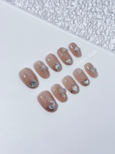 Short milky nude press-on nails with iridescent glitter and 3D crystal droplets, soft winter sugar aesthetic.
