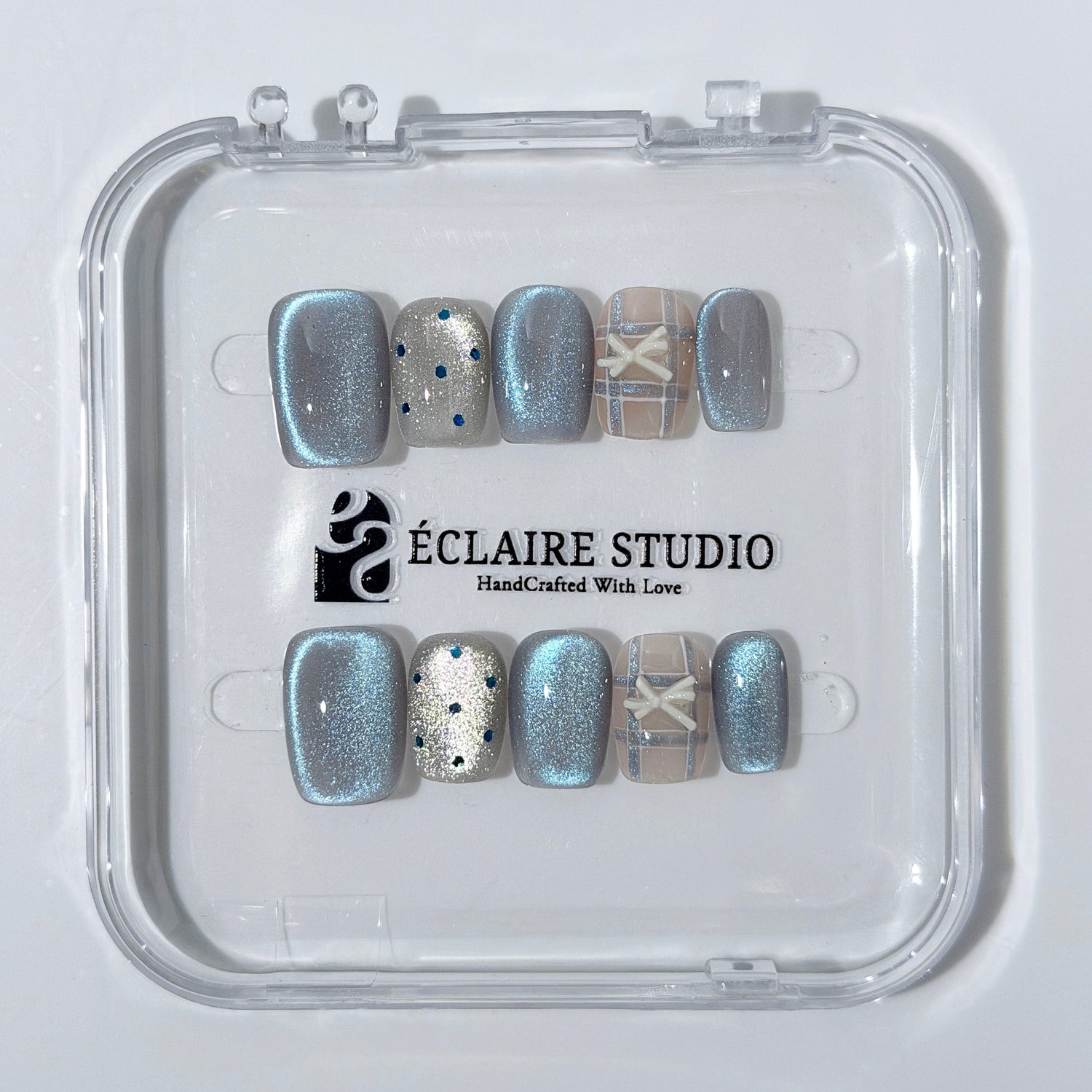 Pastel blue cat-eye press-on nails with glitter accents and 3D clear star details in a soft winter sorbet aesthetic.

