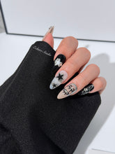 Handmade black, white, and nude press-on nails featuring bows, star charms, and pearl embellishments.