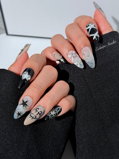 Handmade black, white, and nude press-on nails featuring bows, star charms, and pearl embellishments.
