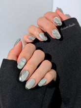 Extra short silver cat-eye press-on nails with chrome ripple accents and 3D heart details, minimalist winter aesthetic.
