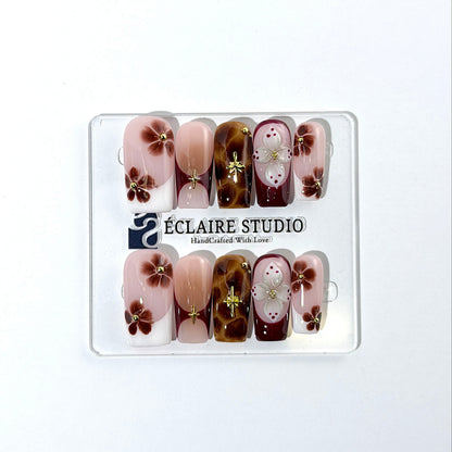 Amber Bloom square press-on nails with blush pink bases, French tips, brown hand-painted flowers, tortoiseshell accents, ivory 3D flowers, and gold details.