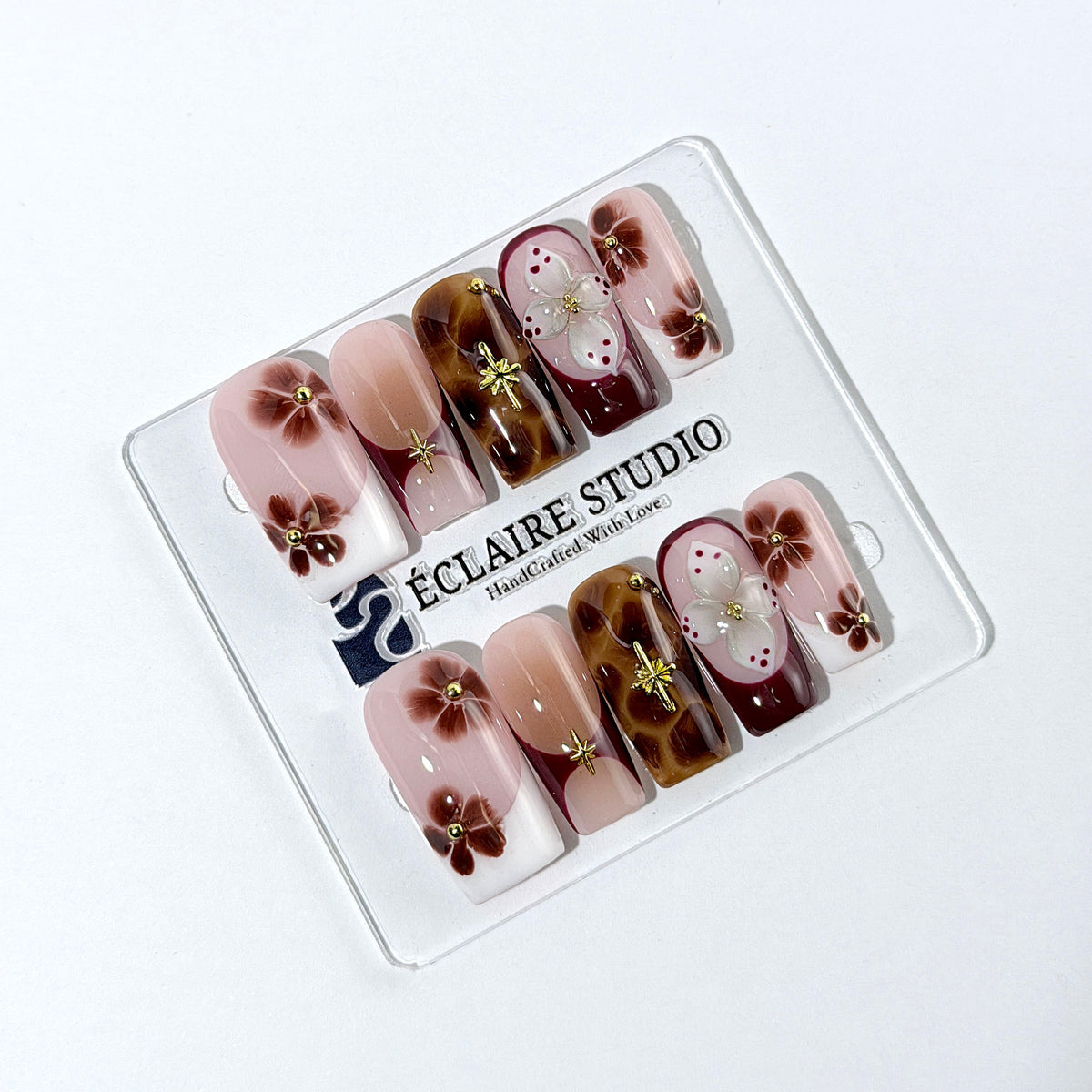 Amber Bloom square press-on nails with blush pink bases, French tips, brown hand-painted flowers, tortoiseshell accents, ivory 3D flowers, and gold details.