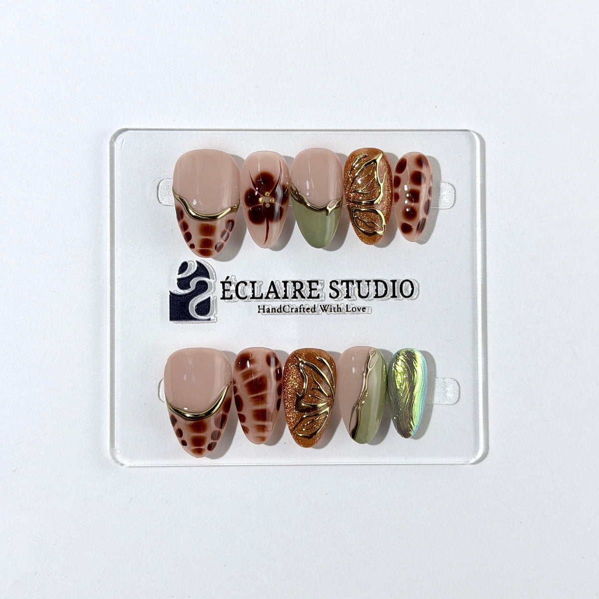 Olive Reverie short almond press-on nails with brown and green cat-eye shimmer, olive French tips, animal prints, floral art, and raised gold details.
