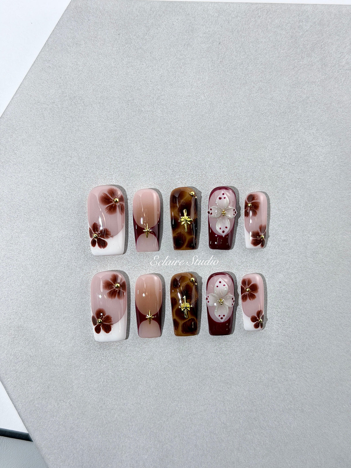 Amber Bloom square press-on nails with blush pink bases, French tips, brown hand-painted flowers, tortoiseshell accents, ivory 3D flowers, and gold details.