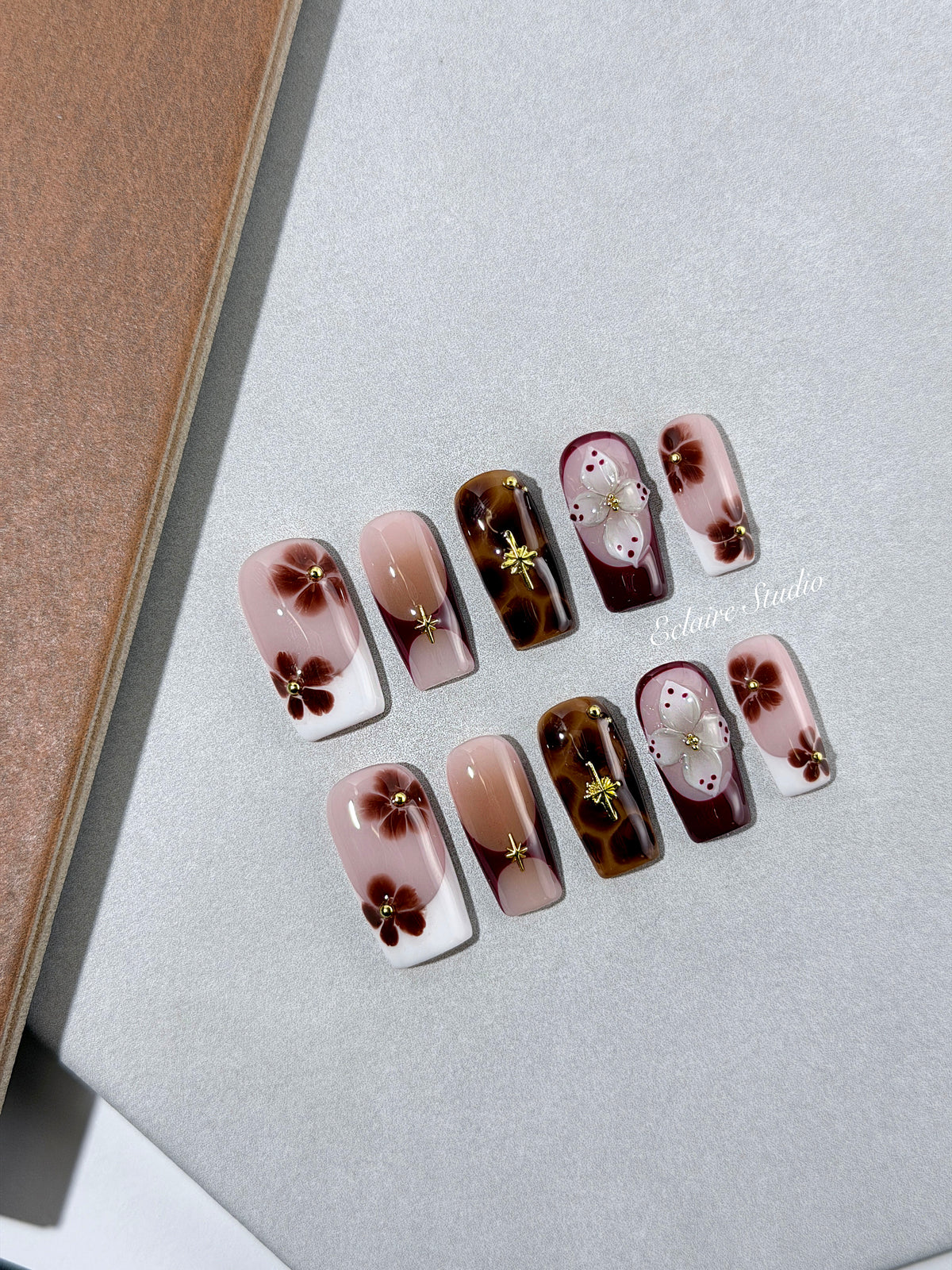 Amber Bloom square press-on nails with blush pink bases, French tips, brown hand-painted flowers, tortoiseshell accents, ivory 3D flowers, and gold details.