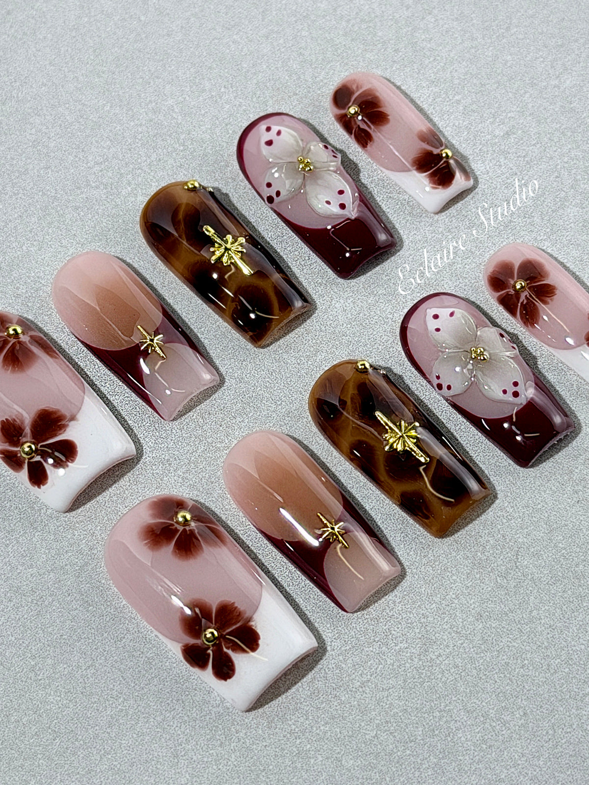 Amber Bloom square press-on nails with blush pink bases, French tips, brown hand-painted flowers, tortoiseshell accents, ivory 3D flowers, and gold details.