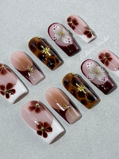 Amber Bloom square press-on nails with blush pink bases, French tips, brown hand-painted flowers, tortoiseshell accents, ivory 3D flowers, and gold details.