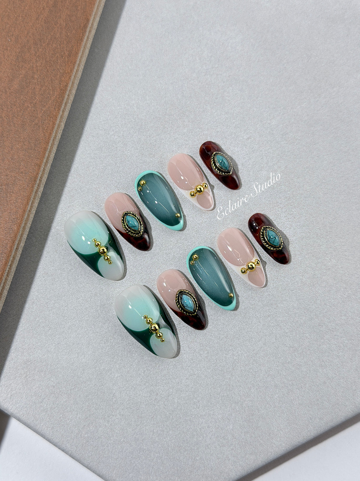 Jasmine’s Secret almond press-on nails with teal and blush bases, tortoiseshell French tips and turquoise jewels – Éclaire Studio
