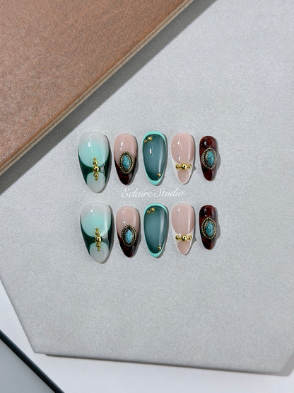Jasmine’s Secret almond press-on nails with teal and blush bases, tortoiseshell French tips, turquoise-toned oval jewels, gold frames, and gold beads.