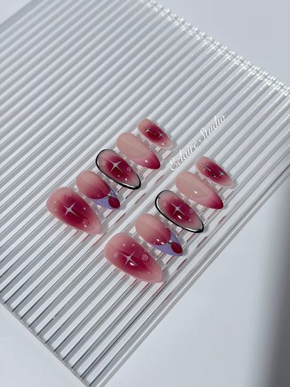 Plum and blush ombré nails with star accents and abstract black outlines — Sugar Plum Fairy–inspired.