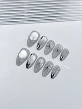 Silver cat-eye press-on nails featuring glazed chrome French tips and fine-line bow and starburst designs.