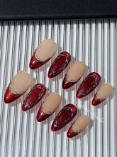 Red press-on nails with deep red cat-eye base, silver strokes, and nude contrast — Éclaire Nail Studio