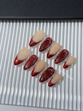 Red press-on nails with deep red cat-eye base, silver strokes, and nude contrast — Éclaire Nail Studio