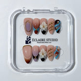 Warm gradient nails with gold trim, 3D white flowers, and blue accents inspired by the Nutcracker character