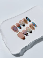 Warm gradient nails with gold trim, 3D white flowers, and blue accents inspired by the Nutcracker character