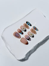 Warm gradient nails with gold trim, 3D white flowers, and blue accents inspired by the Nutcracker character