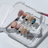 Warm gradient nails with gold trim, 3D white flowers, and blue accents inspired by the Nutcracker character