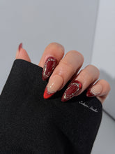 Red press-on nails with deep red cat-eye base, silver strokes, and nude contrast — Éclaire Nail Studio