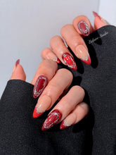 Red press-on nails with deep red cat-eye base, silver strokes, and nude contrast — Éclaire Nail Studio