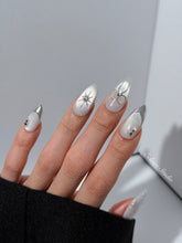Silver cat-eye press-on nails featuring glazed chrome French tips and fine-line bow and starburst designs.