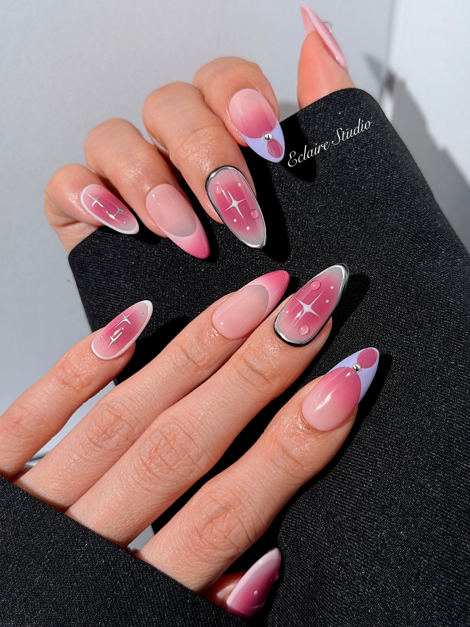 Plum and blush ombré nails with star accents and abstract black outlines — Sugar Plum Fairy–inspired.