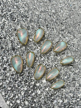 Opal stones on a textured gray surface