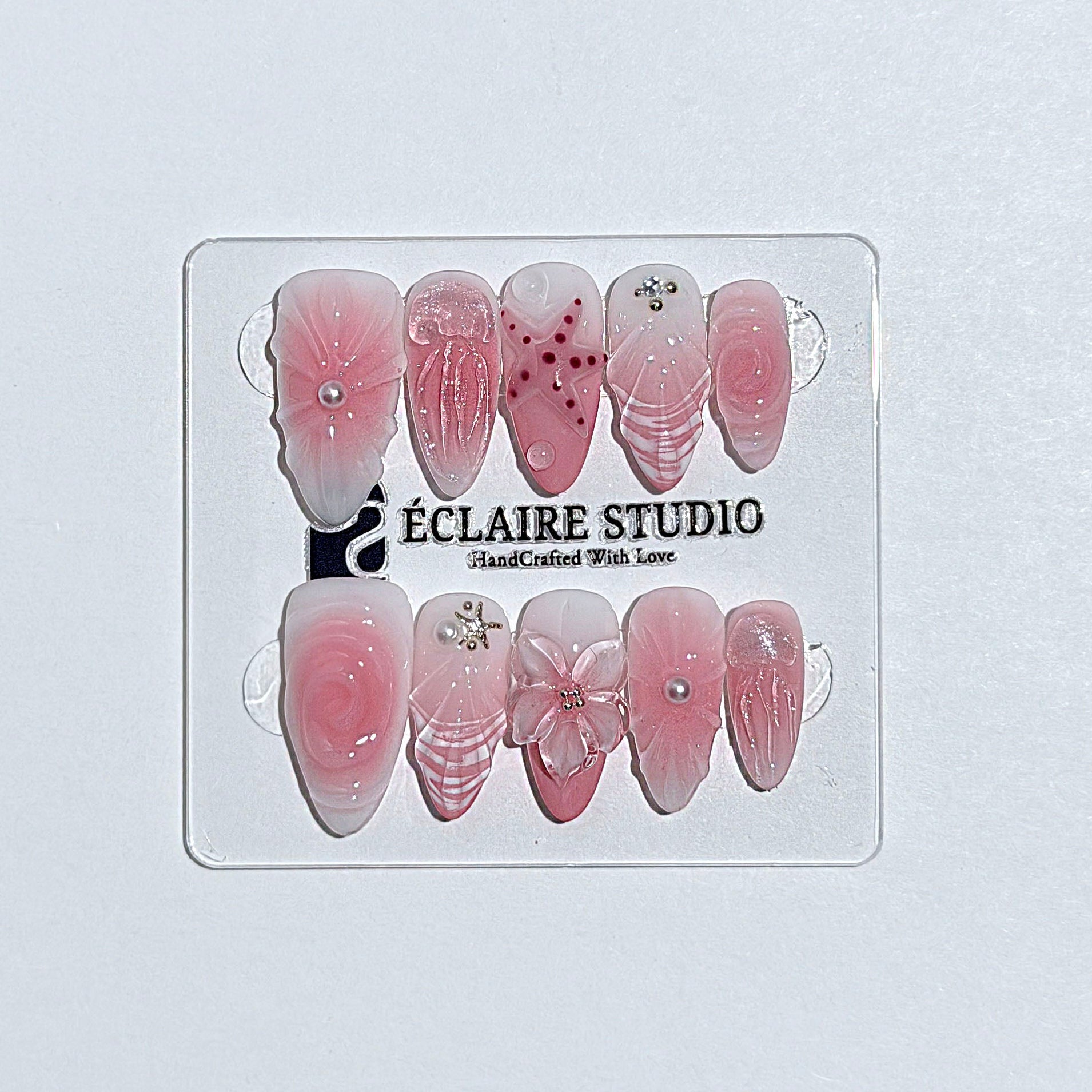 Luxury press-on nails featuring a soft blush pink ombre base with white French tips, a translucent 3D jellyfish, a sculpted pink starfish, and a clear 3D glass flower with a pearl center.