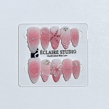 Luxury press-on nails featuring a soft blush pink ombre base with white French tips, a translucent 3D jellyfish, a sculpted pink starfish, and a clear 3D glass flower with a pearl center.