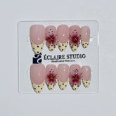 Eclaire Nail Studio Luxury medium almond press-on nails featuring sheer pink bases with vintage cream French tips, burgundy polka dots, and hand-sculpted 3D burgundy flowers with gold bead centers.