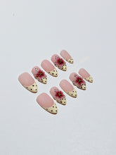 Luxury medium almond press-on nails featuring sheer pink bases with vintage cream French tips, burgundy polka dots, and hand-sculpted 3D burgundy flowers with gold bead centers.